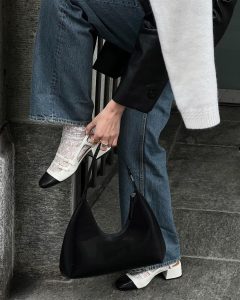 Mary usando calça jeans, meia de renda branca e sapato boneca bicolor no estilo slingback