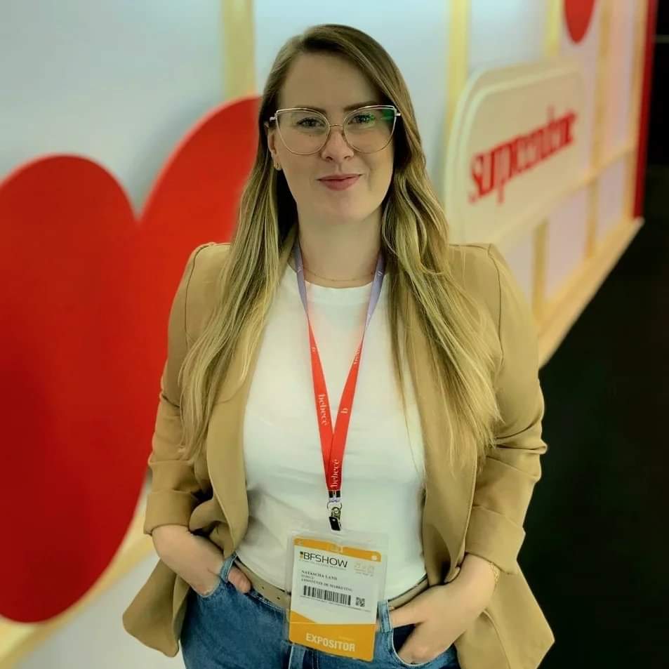 Mulher loira usa óculos e veste blazer caramelo