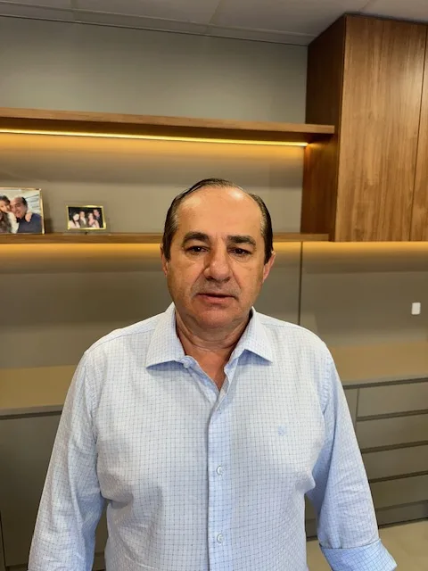 Homem em pé, com camisa clara xadrez