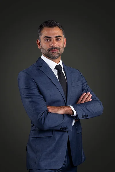 Homem em pé, vestido com terno azul-marinho