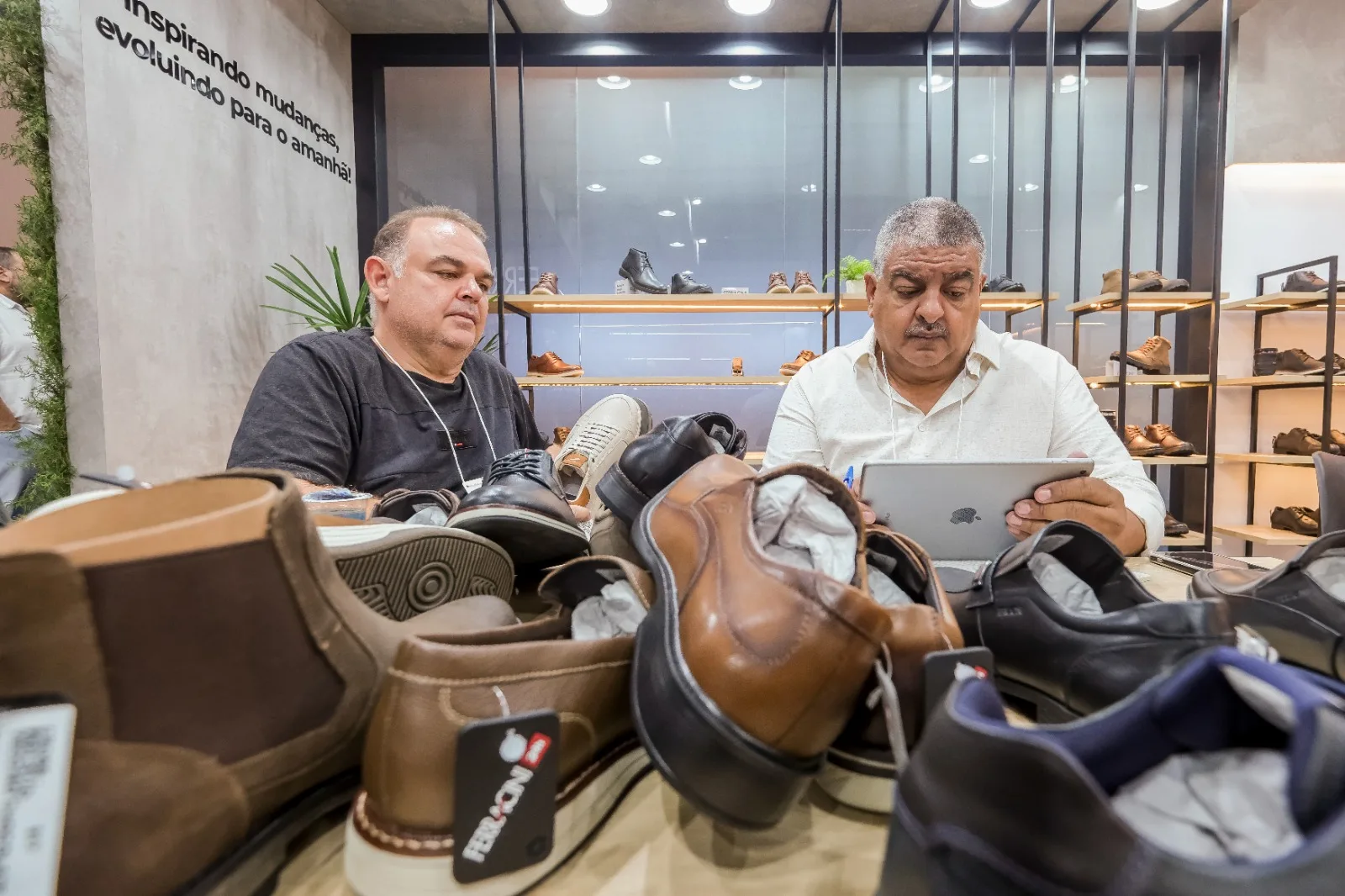 Dois homens frente a vários sapatos