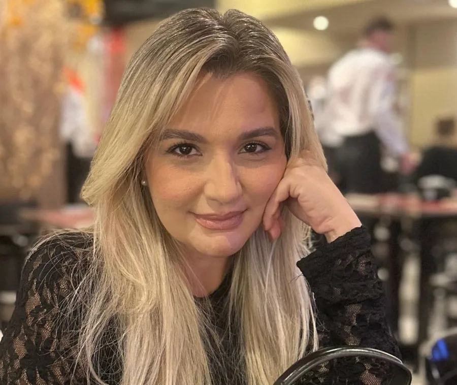 Mulher loira com a mão no rosto