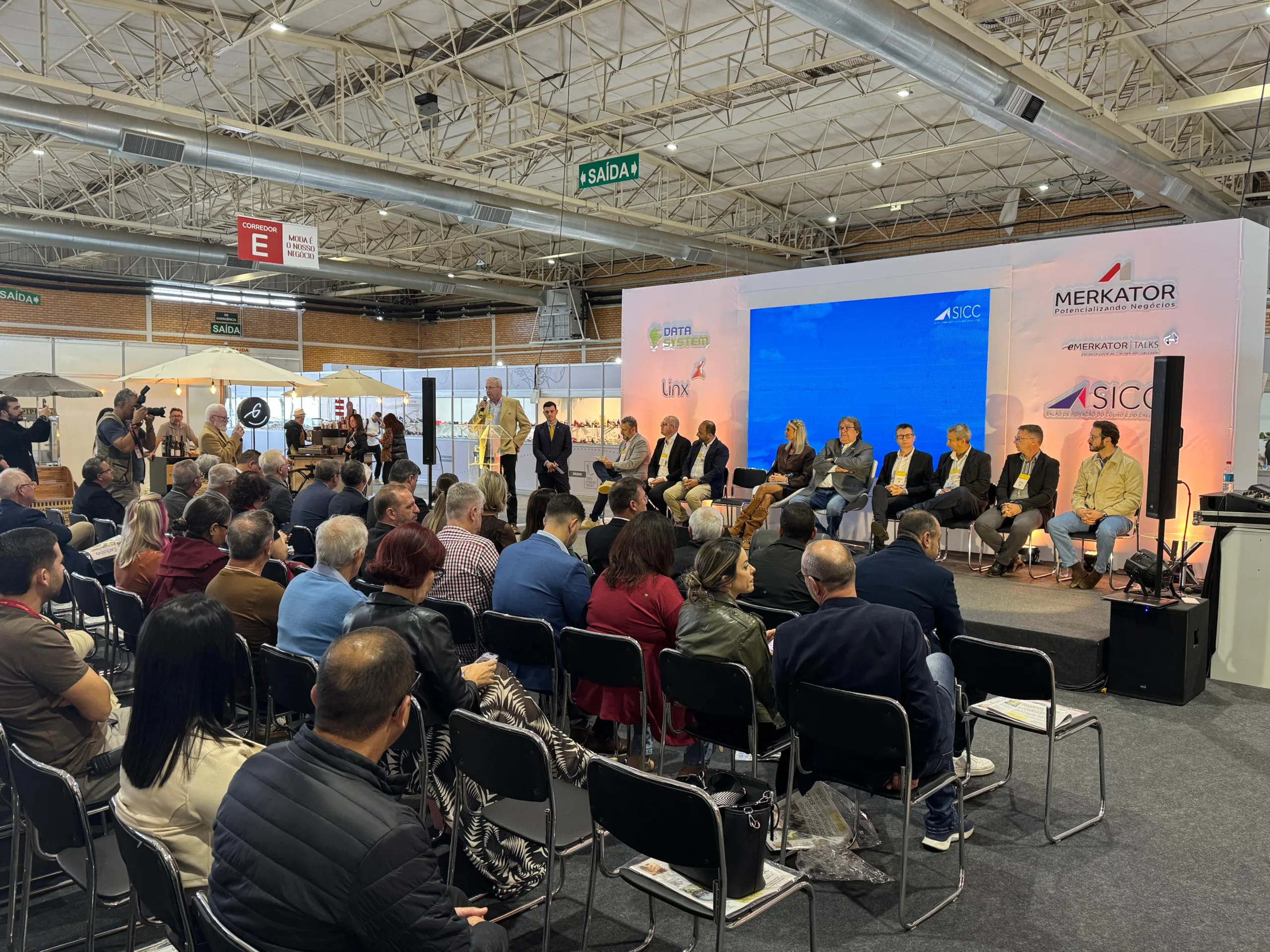 Ambiente com palco e várias pessoas na platéia