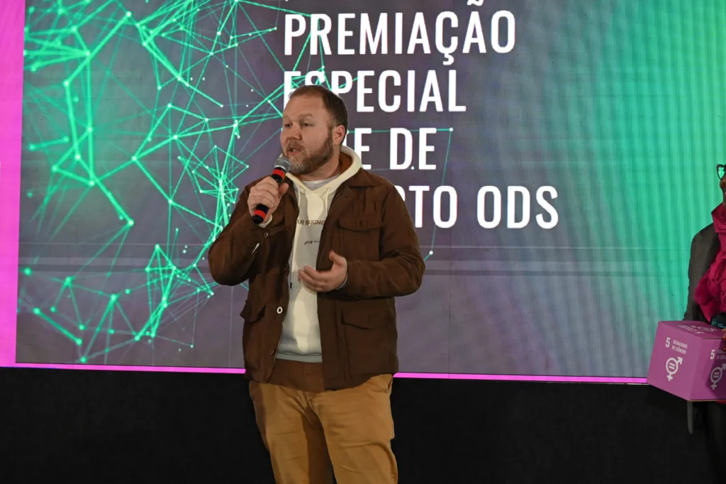 Homem em pé falando ao microfone